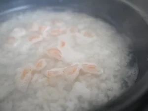 海老と菜の花のお粥　土鍋にごはんと水を入れ、中火にかけ沸騰したら弱火にし海老を加える