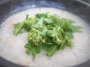 海老と菜の花のお粥　土鍋に菜の花を加える